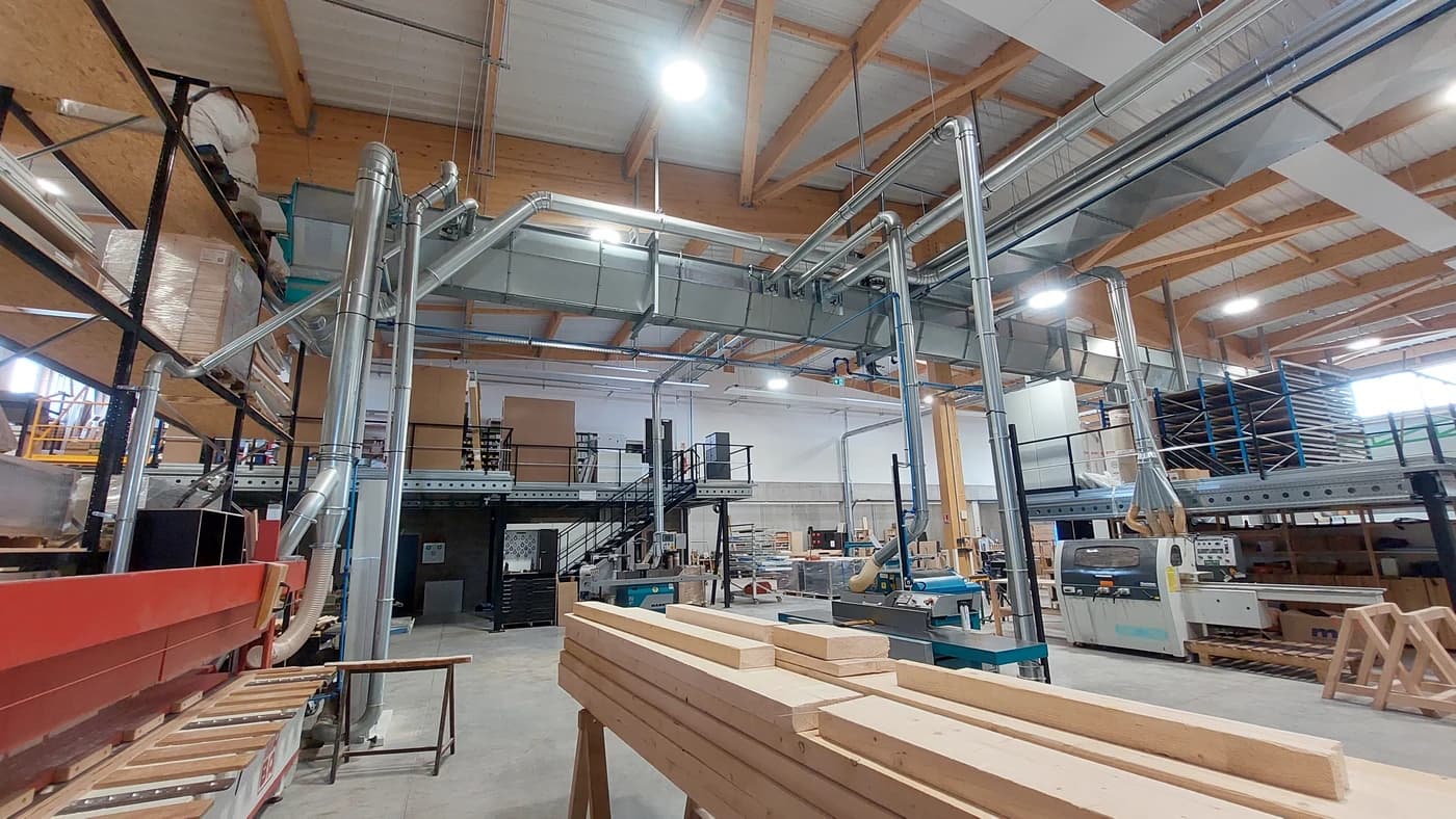 Atelier bois avec réseau centralisé de captage des poussières - gaines d'aspiration au-dessus des machines