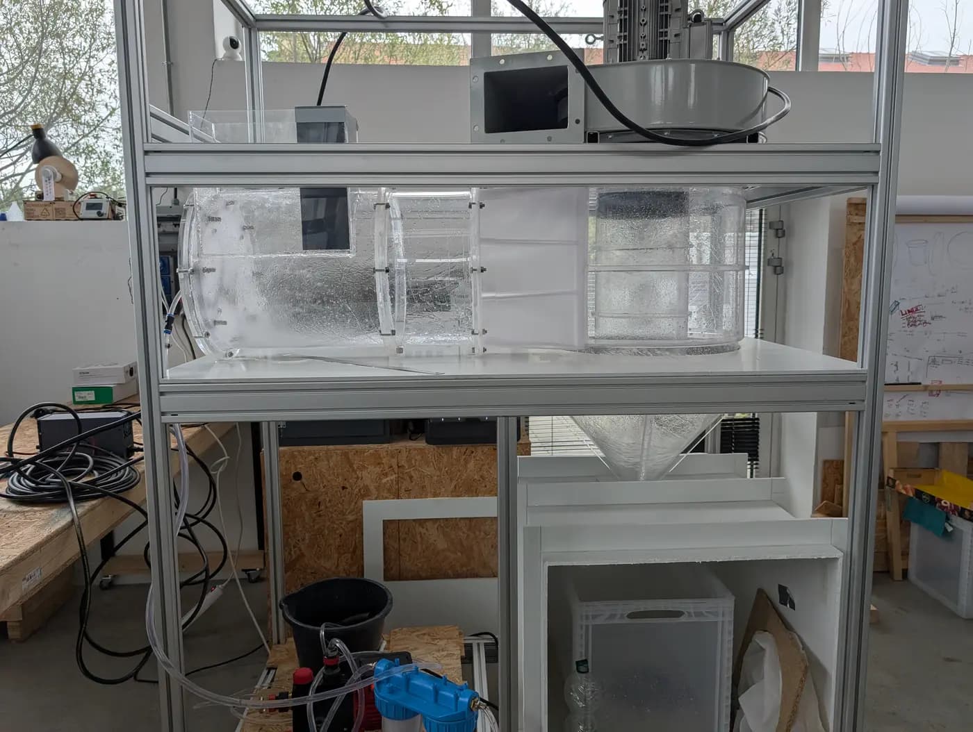 Banc d’essai AERO en atelier : prototype transparent du contacteur cyclonique de filtration par voie humide, sur châssis aluminium, avec cyclone et collecte des boues.