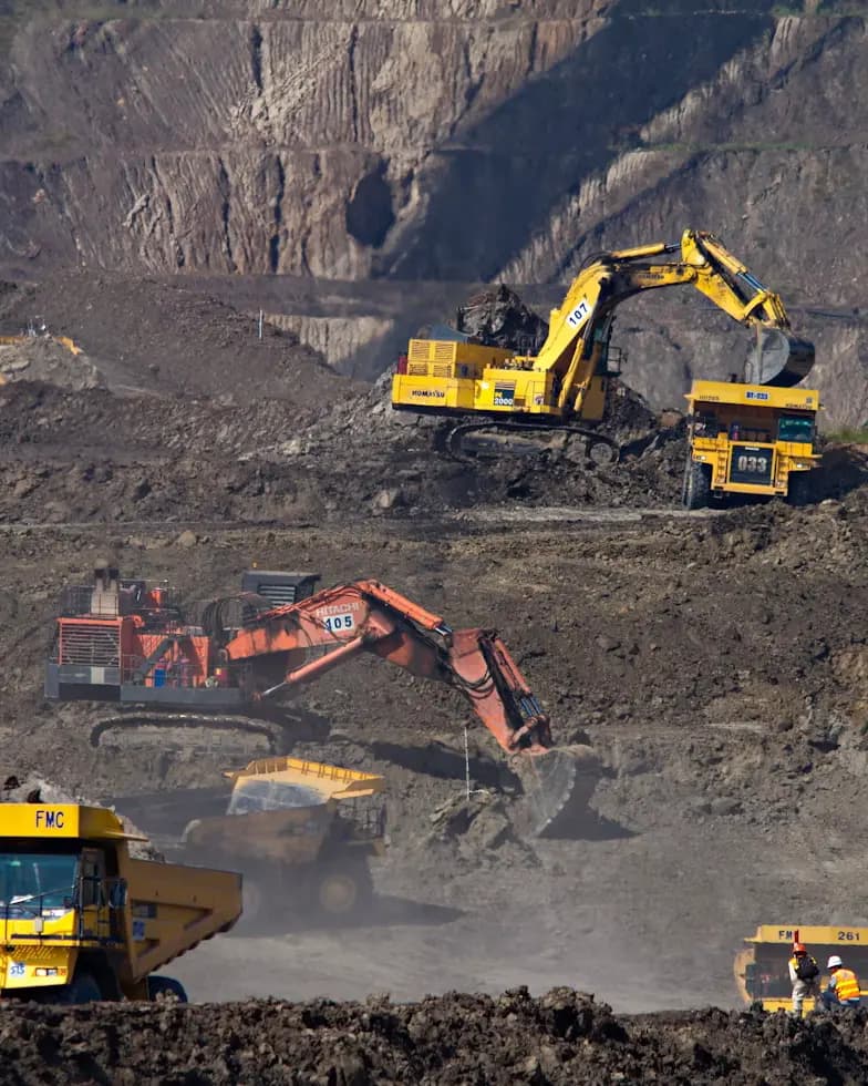 Pelles et tombereaux en exploitation dans une mine à ciel ouvert.