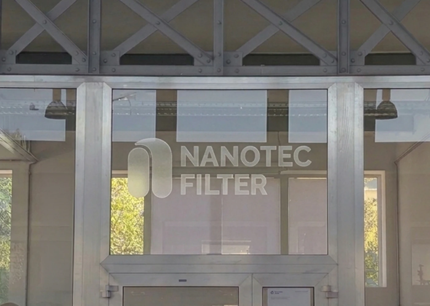 Façade vitrée des locaux de Nanotec Filter avec le logo - bureau d’études en qualité de l’air, Nancy.